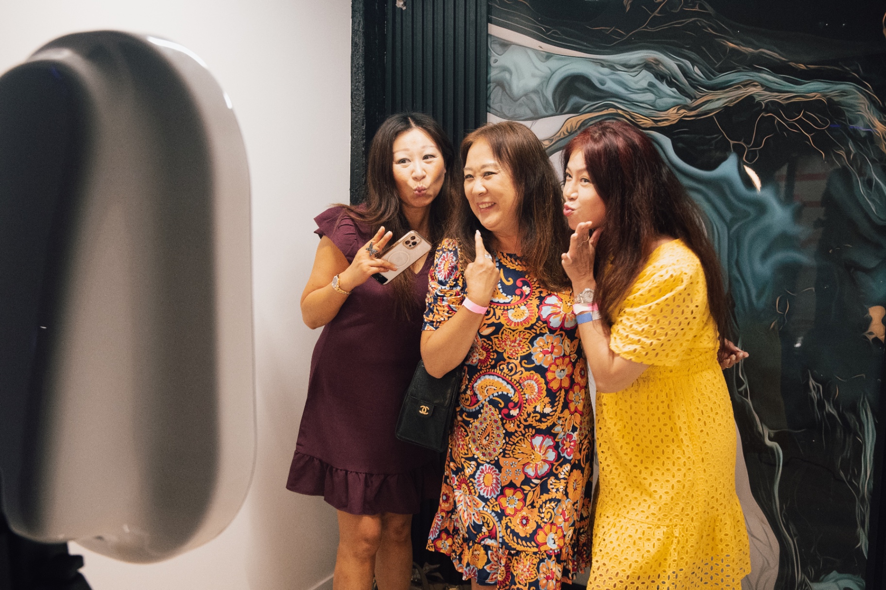Friends posing together at an indoor event photo booth in Los Angeles