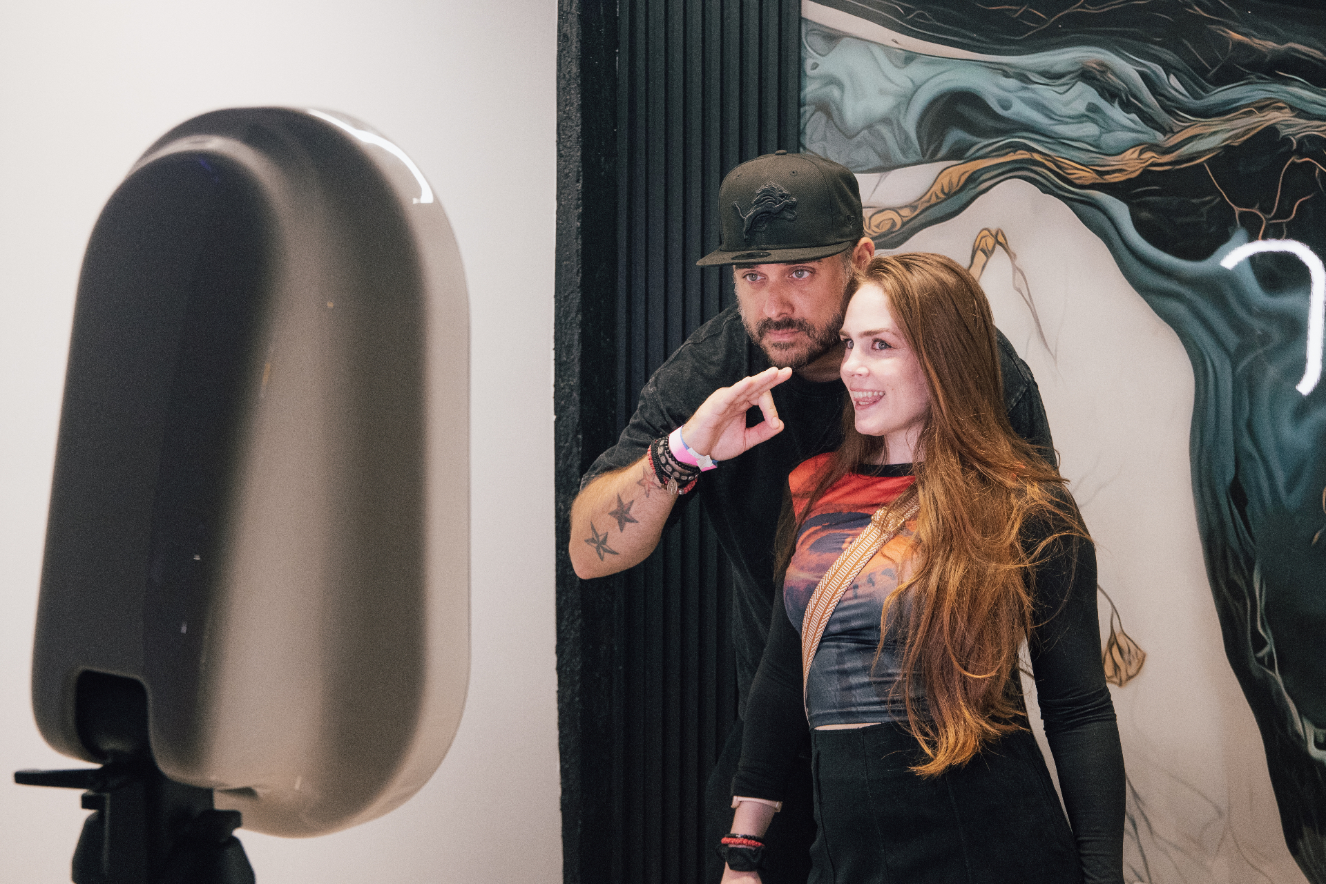 Couple posing at a MOMNT photo booth inside a Los Angeles art gallery